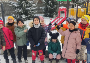 Zdjęcie grupowe na dworze podczas przypinania pamiątkowej kłódki.