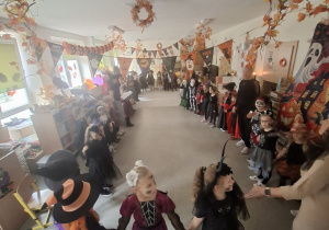 Dzieci z Chatki Puchatka bawią się na balu halloween.
