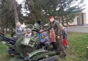 Dzieci w obecności żołnierzy oglądają działa.