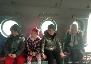 Dzieci siedzą w samolocie wojskowym.