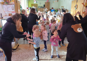 Dzieci tańczą na przyjęciu misiowym.