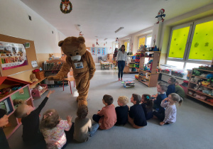 Dzieci bawią się z dużym misiem Teddym.