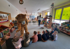 Dzieci bawią się z dużym misiem Teddym.