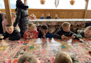 Dzieci jedzą chleb z dżemem.