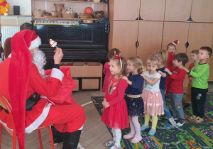 Dzieci rozmawiają z Mikołajem.