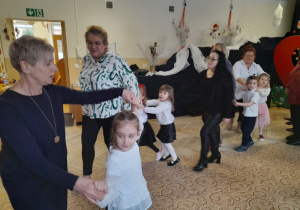 Dzieci bawią się z dziadkami na uroczystości.