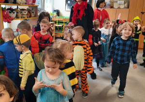 Dzieci przebrane za postacie z bajek bawią się na balu ostatkowym.