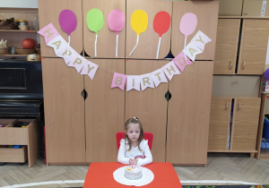 Dziewczynka raduje się na przyjęciu urodzinowym.