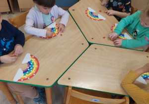 Dzieci wykonują tęczę z kolorowego papieru