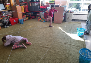 Dzieci przechodzą przez pajęczynę.