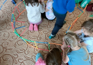 Dzieci tworzą konstrukcję z klocków.
