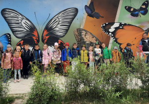 Zdjęcie grupowe na tle motyli malowanych na ścianie.