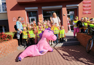 Dzieci maszerują ulicami miasta świętując dzień przedszkolaka.