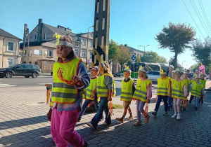 Dzieci maszerują ulicami miasta świętując dzień przedszkolaka.