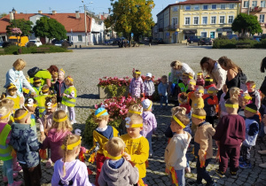 Dzieci maszerują ulicami miasta świętując dzień przedszkolaka.