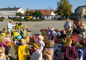 Dzieci maszerują ulicami miasta świętując dzień przedszkolaka.