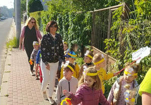 Dzieci maszerują ulicami miasta świętując dzień przedszkolaka.