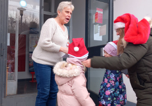 Dzieci wręczają kartkę świąteczną na poczcie.