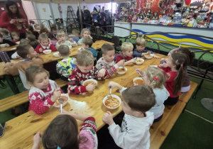 Dzieci jedzą ciepły posiłek.