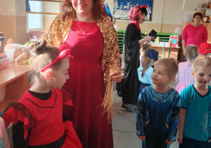 Dzieci przebrane za postacie z bajek bawią się na balu karnawałowym.