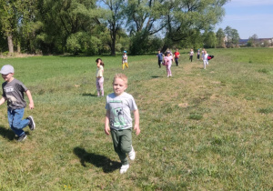 Dzieciaki szaleją na łące.