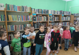 Zdjęcie grupowe wśród półek z książkami.