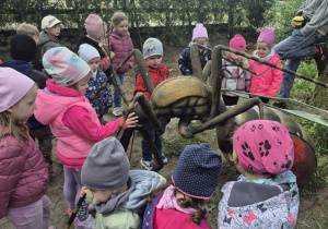 Dzieci oglądają figurę owada na ścieżce edukacyjnej.