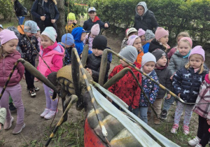 Dzieci oglądają figurę owada na ścieżce edukacyjnej.