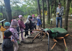 Dzieci oglądają figurę owada na ścieżce edukacyjnej.