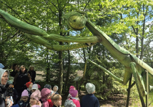 Dzieci oglądają figurę owada na ścieżce edukacyjnej.