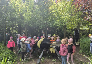 Dzieci oglądają figurę owada na ścieżce edukacyjnej.