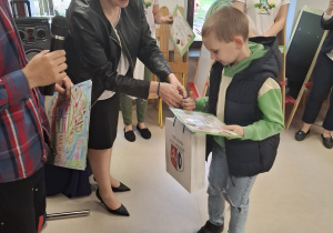Adaś odbiera dyplom i upominek.