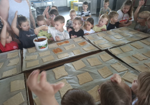 Dzieci przy dużym stole robią własne wypieki.