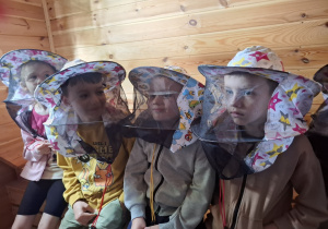 Dzieci w ochronnych nakryciach głowy.