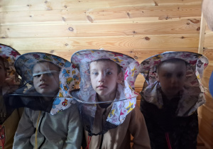 Dzieci w ochronnych nakryciach głowy.
