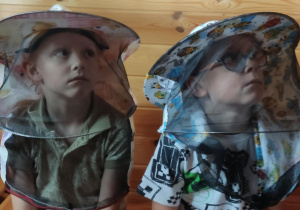 Dzieci w ochronnych nakryciach głowy.
