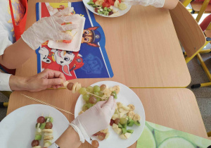 Dzieci kroją owoce na małe części.