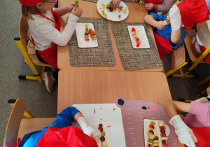 Dzieci układają szaszłyki.