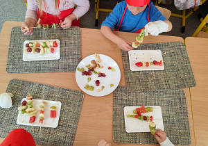 Dzieci układają szaszłyki.