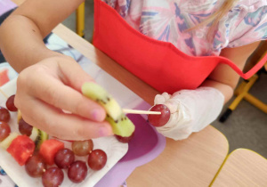 Dzieci układają szaszłyki.