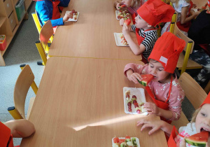 Dzieci układają szaszłyki.