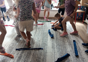 Sportowiec pokazuje dzieciom ćwiczenia karate.