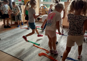 Sportowiec pokazuje dzieciom ćwiczenia karate.