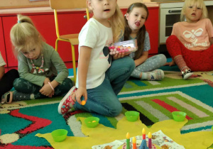 Jubilatka rozkłada koraliki na słoneczku urodzinowym.