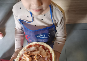 Dziecko z własnoręcznie zrobioną pizzą.