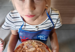 Dziecko z własnoręcznie zrobioną pizzą.