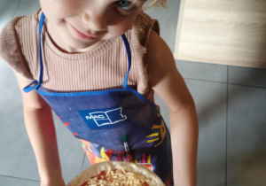 Dziecko z własnoręcznie zrobioną pizzą.