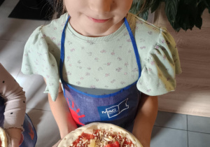 Dziecko z własnoręcznie zrobioną pizzą.