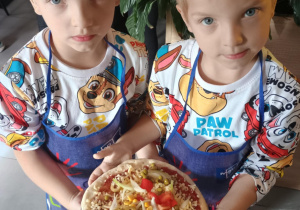 Dziecko z własnoręcznie zrobioną pizzą.