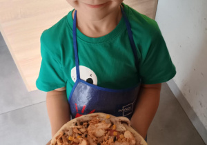 Dziecko z własnoręcznie zrobioną pizzą.